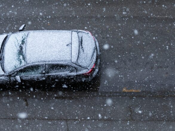 Black car on the road under the snow in spring in New Zagreb, Croatia